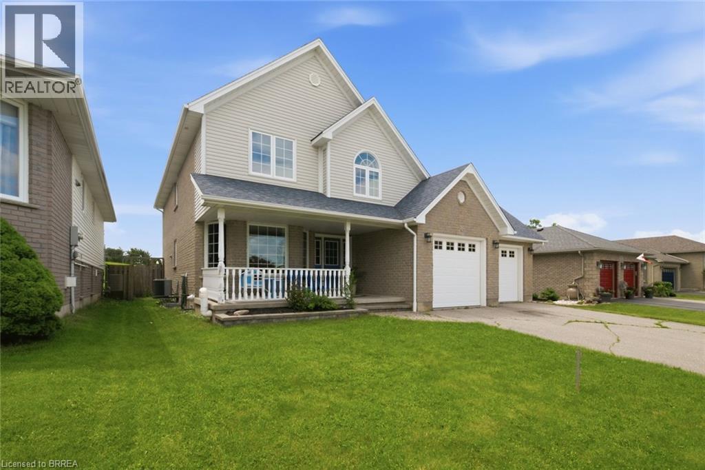 Two-story residence featuring light-colored siding and brick accents - 61 Sunnyside Drive, St. George, ON