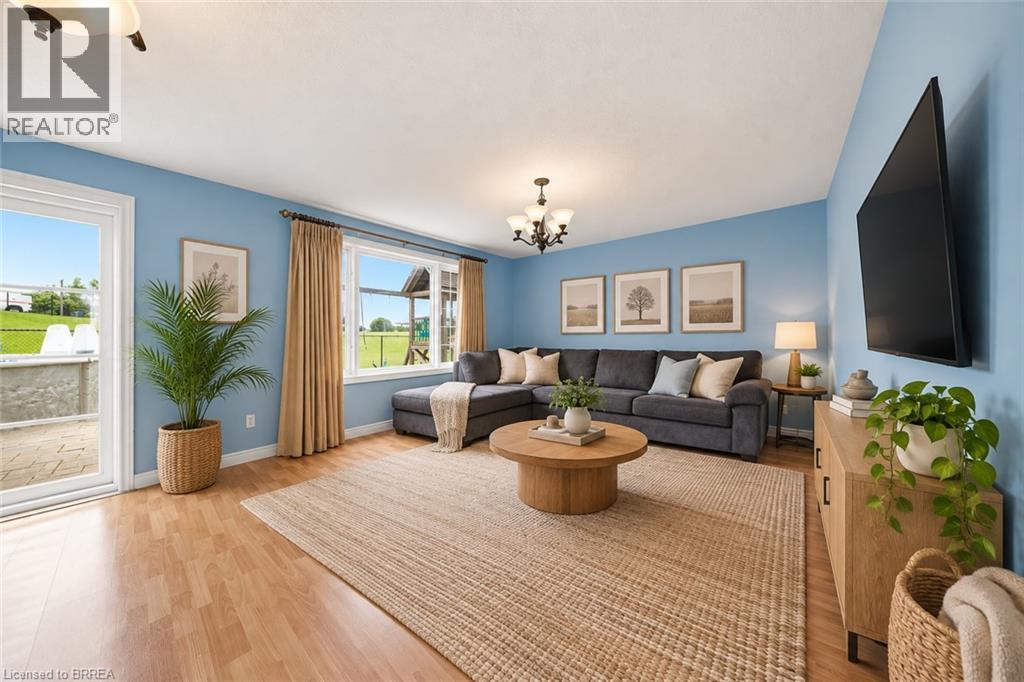 Light wood-finish flooring, recessed lighting, and a glass-paneled patio door - 61 Sunnyside Drive, St. George, ON
