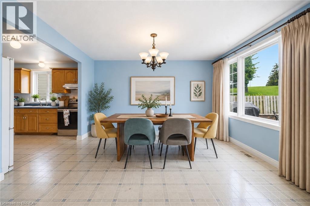 Expansive window, overhead chandelier, light-colored flooring, kitchen with wood cabinetry - 61 Sunnyside Drive, St. George, ON