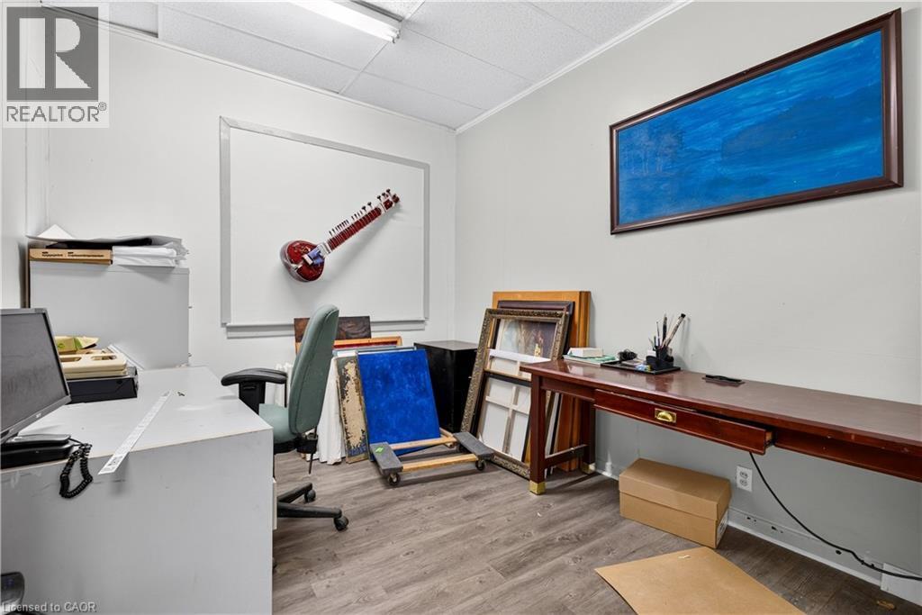 Wood-finish flooring, white walls, and a suspended acoustic tile ceiling - 689 E Barton Street E, Hamilton, ON