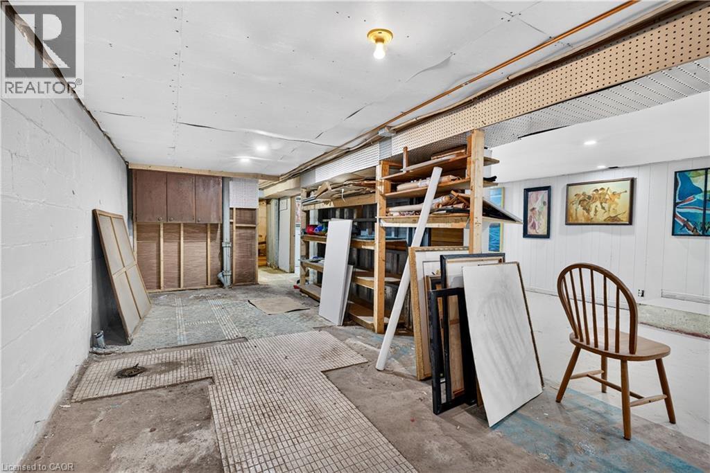 Basement area featuring concrete flooring, exposed block walls, and overhead lighting - 689 E Barton Street E, Hamilton, ON