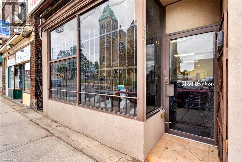 Commercial storefront with expansive display windows, street-level entrance, and tiled entry - 689 E Barton Street E, Hamilton, ON