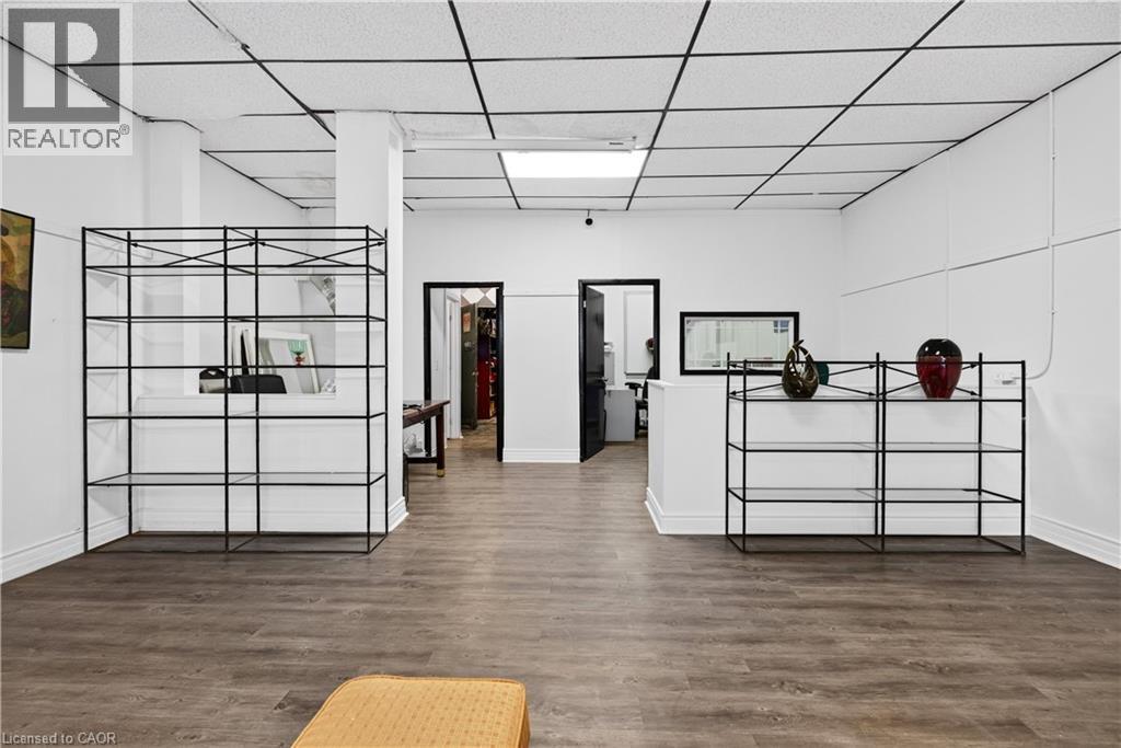 Wood-finish flooring, white walls, and a drop ceiling with integrated lighting - 689 E Barton Street E, Hamilton, ON