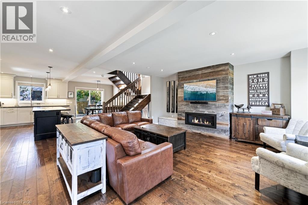 Built-in linear gas fireplace with barn board mantel. Hand scrapped hardwood. Pot lights throughout. - 58 Uplands Avenue, Hamilton, ON