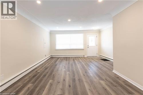 Recessed lighting, crown molding, wood-finish flooring, and a paneled entry door with frosted glass insert - 499 East 16Th Street, Hamilton, ON 