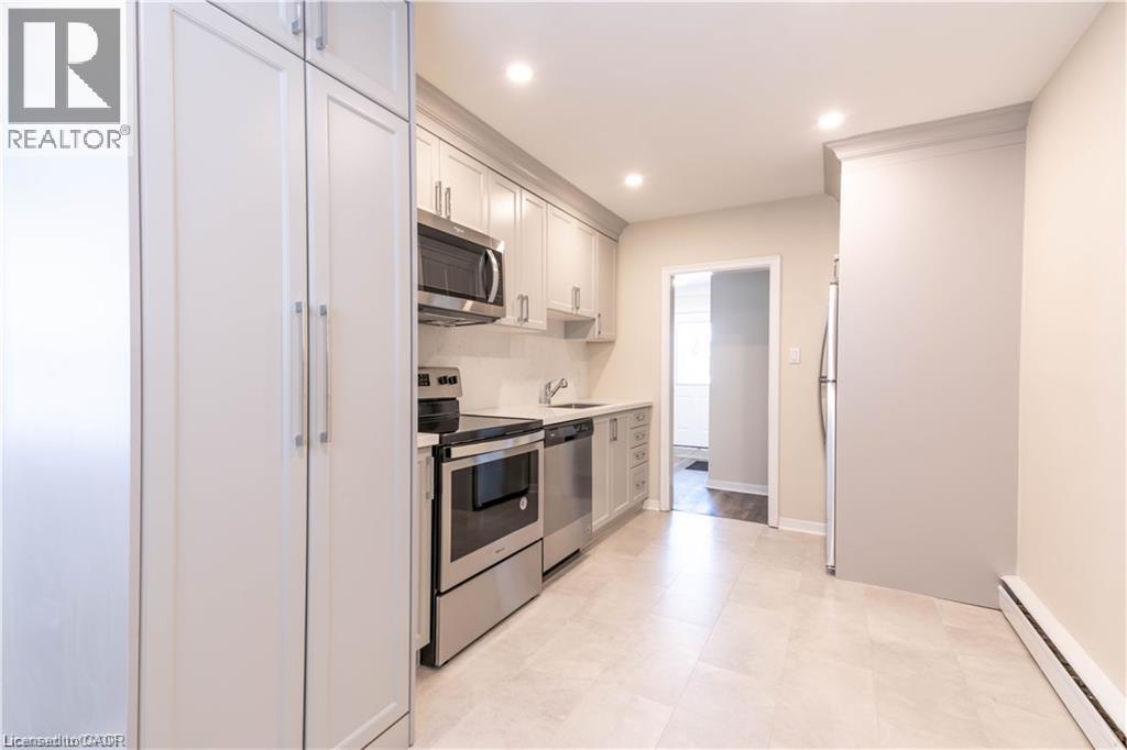 Kitchen featuring light-toned cabinetry, stainless steel appliances, recessed lighting, and tile flooring - 499 East 16Th Street, Hamilton, ON