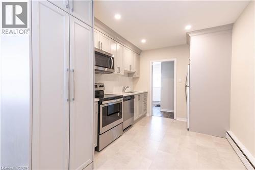 Kitchen featuring light-toned cabinetry, stainless steel appliances, recessed lighting, and tile flooring - 499 East 16Th Street, Hamilton, ON 