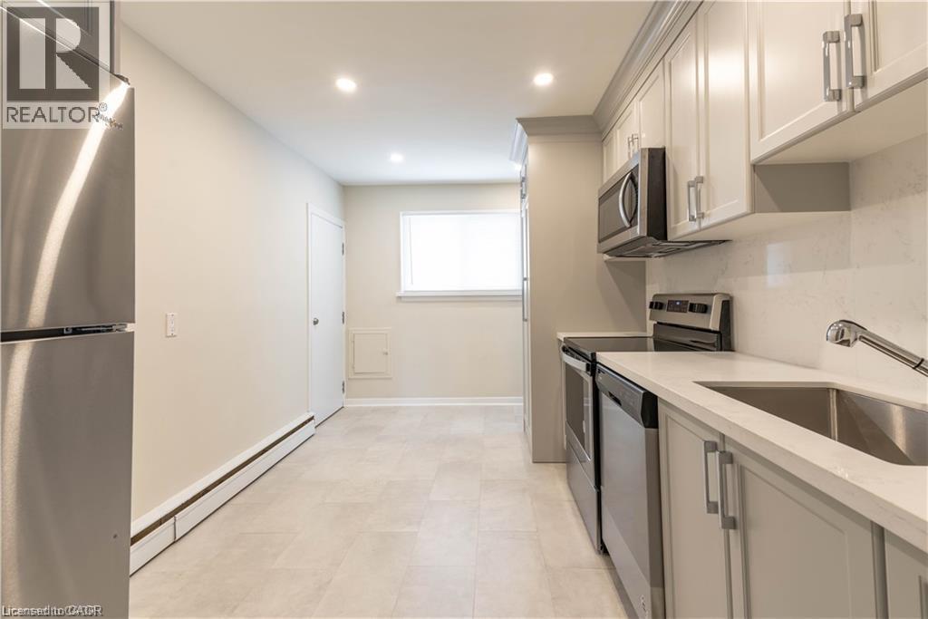 Modern kitchen featuring light cabinetry, stainless steel appliances, a single-basin sink, and recessed lighting - 499 East 16Th Street, Hamilton, ON