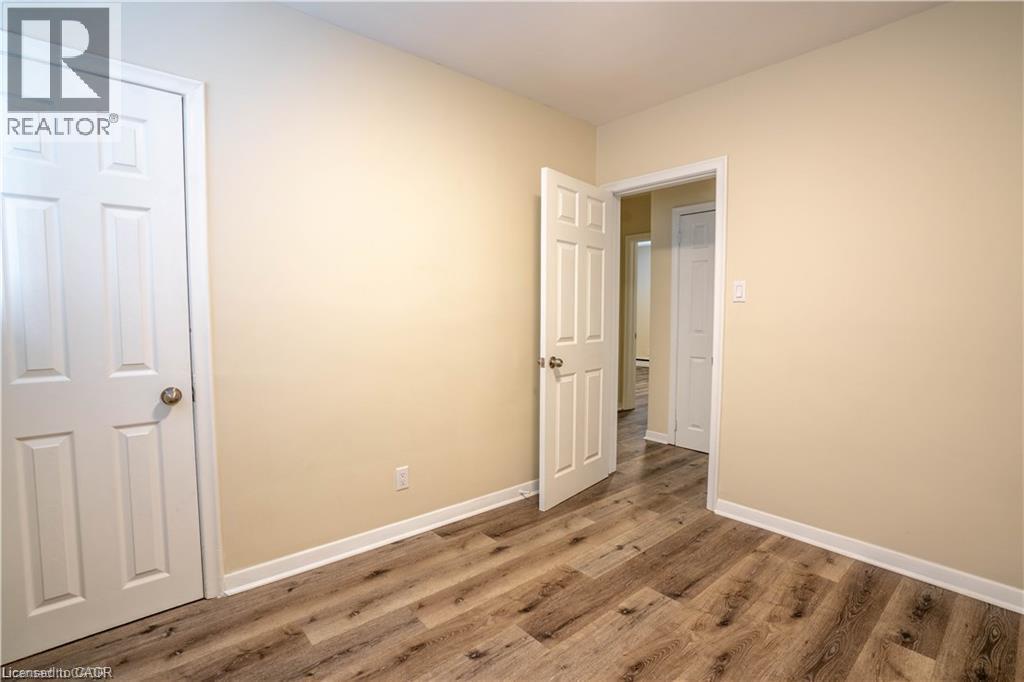 Wood-finish flooring, neutral wall paint, and white trim throughout - 499 East 16Th Street, Hamilton, ON