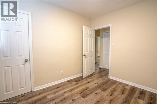 Wood-finish flooring, neutral wall paint, and white trim throughout - 499 East 16Th Street, Hamilton, ON 