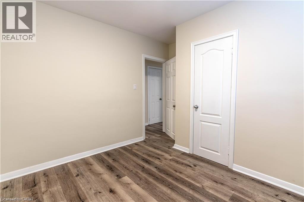 Wood-finish flooring, light-toned wall paint, and white trim - 499 East 16Th Street, Hamilton, ON