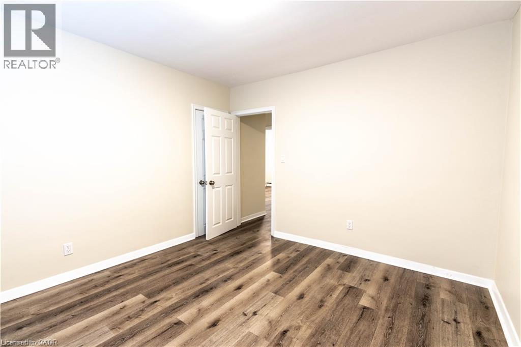 Wood-finish flooring, neutral wall tones, and white trim - 499 East 16Th Street, Hamilton, ON
