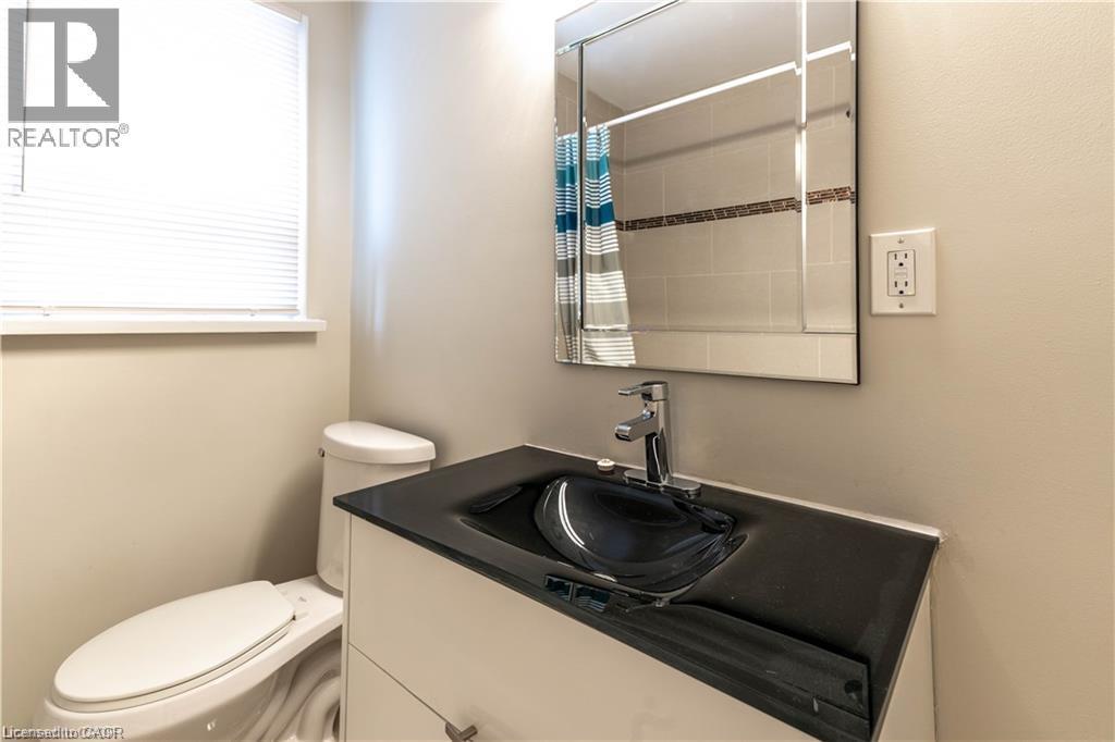 White vanity with a black integrated sink and chrome faucet - 499 East 16Th Street, Hamilton, ON