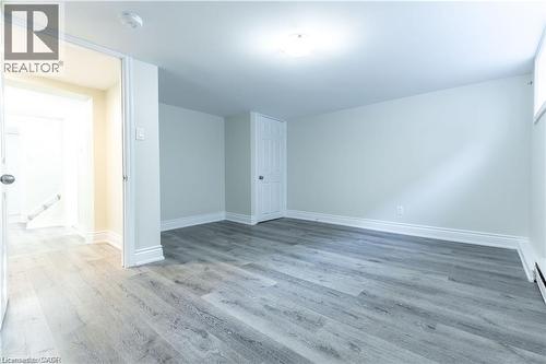 Wood-finish flooring, white trim, recessed ceiling light, white walls, and a solid interior door - 499 East 16Th Street, Hamilton, ON 
