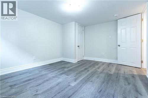 Wood-finish flooring, white trim, and a white ceiling with an overhead light fixture - 499 East 16Th Street, Hamilton, ON 