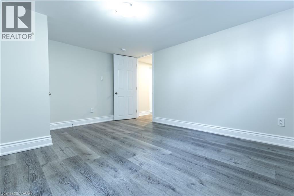 Wood-finish flooring, white trim, recessed lighting, and a white interior door - 499 East 16Th Street, Hamilton, ON