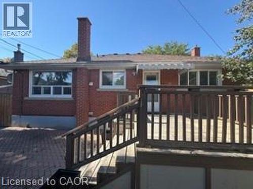 Red brick exterior with multiple windows and a prominent chimney - 499 East 16Th Street, Hamilton, ON 