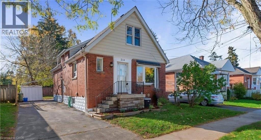 Brick exterior with white siding, covered entryway, and asphalt driveway - 284 Brucedale Avenue E, Hamilton, ON