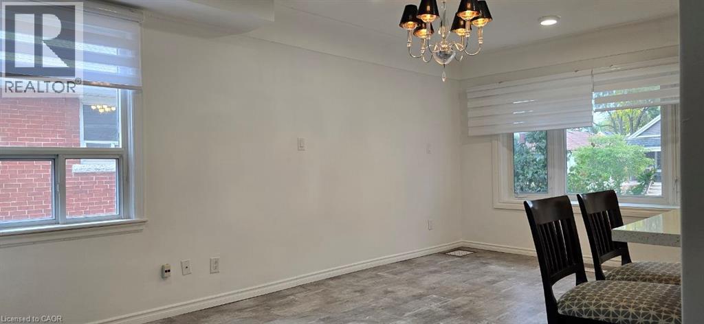 Recessed lighting, crown molding, wood-finish flooring, white walls, and a chandelier with black shades - 284 Brucedale Avenue E, Hamilton, ON