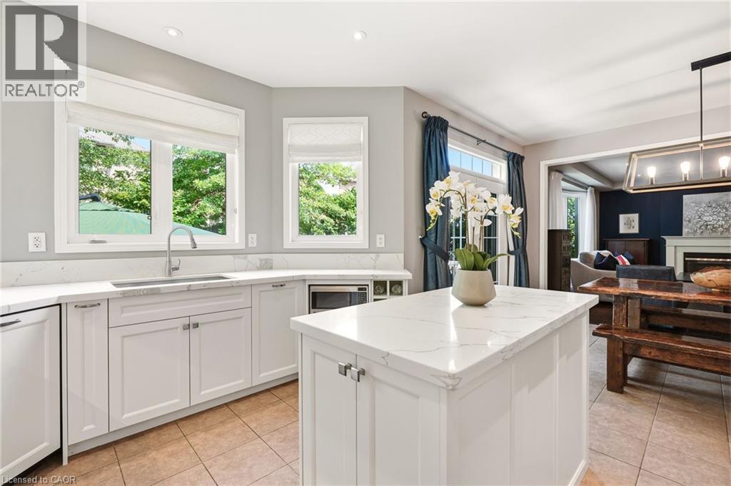 Bright, chef-inspired kitchen featuring white shaker cabinetry, white quartz countertops, and a substantial center island with prep space - 536 Cusick Circle, Milton, ON