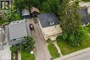 Two-story residence with a front balcony and covered porch, featuring a dormer window, a paved driveway, and mature landscaping - 275 Main Street, Cambridge, ON 