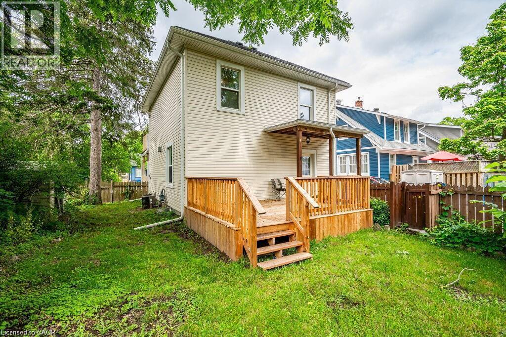 Rear exterior with horizontal siding, wooden deck, wooden steps, covered porch, and a fenced yard - 275 Main Street, Cambridge, ON