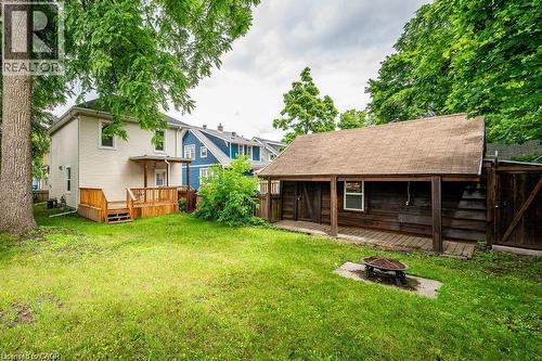 Expansive grassy yard featuring a wooden deck, a covered porch, and a detached shed with a shingled roof - 275 Main Street, Cambridge, ON 