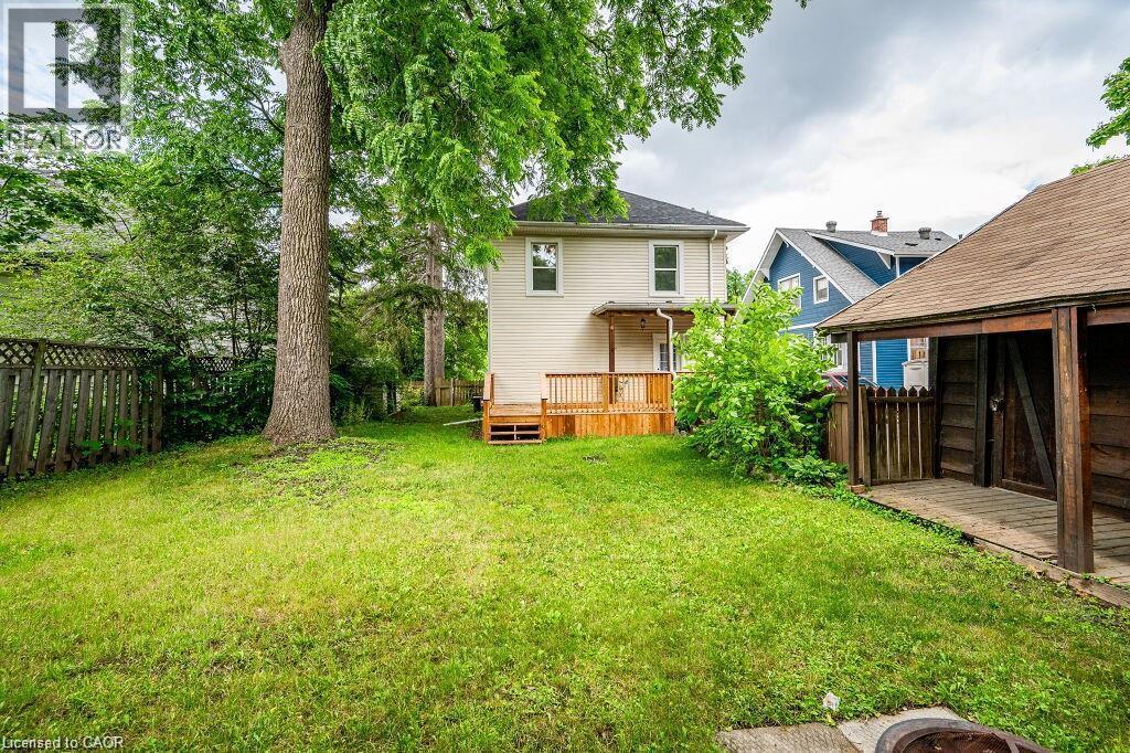 Expansive grassy yard with mature trees, a wooden deck, and a detached shed - 275 Main Street, Cambridge, ON