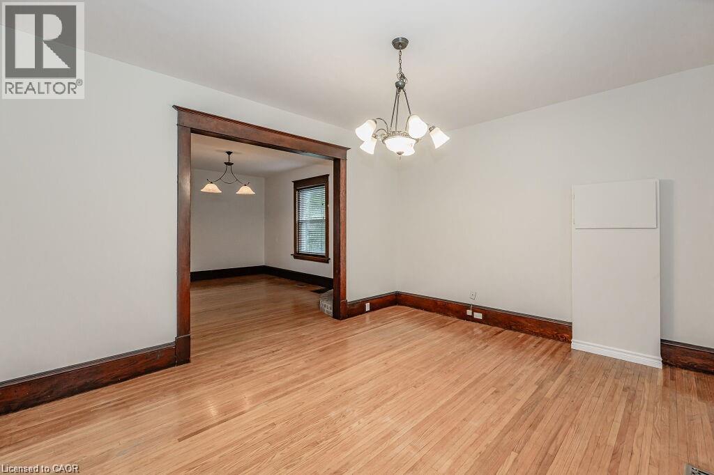 Hardwood flooring, dark wood trim, classic chandelier, and a wide cased opening - 275 Main Street, Cambridge, ON