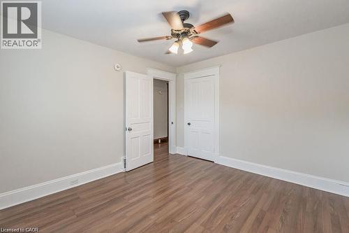 Wood-finish flooring, white trim, paneled doors, and a ceiling fan with light fixture - 275 Main Street, Cambridge, ON 
