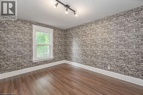 Wood-finish flooring, white trim, track lighting fixture, and a single window - 275 Main Street, Cambridge, ON 