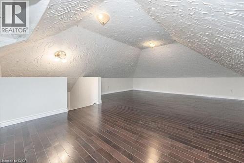Expansive attic space featuring wood-finish flooring, sloped ceilings, and recessed lighting - 275 Main Street, Cambridge, ON 