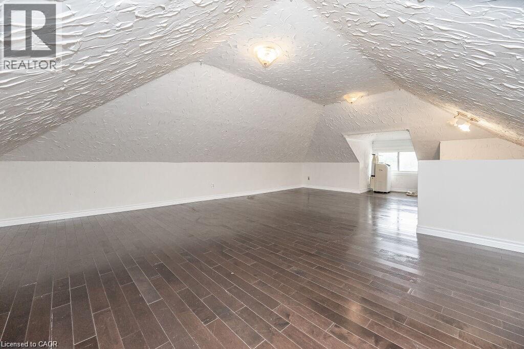 Sloped ceilings with textured finish, recessed lighting, and wood-finish flooring - 275 Main Street, Cambridge, ON