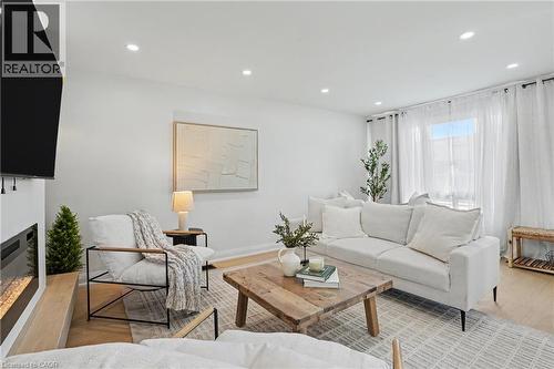 Recessed lighting, light wood-finish flooring, and a modern fireplace with a light wood hearth - 311 East 14Th Street, Hamilton, ON 