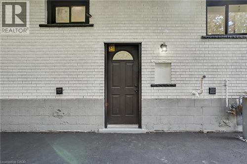 Exterior featuring white brick and concrete block construction - 311 East 14Th Street, Hamilton, ON 