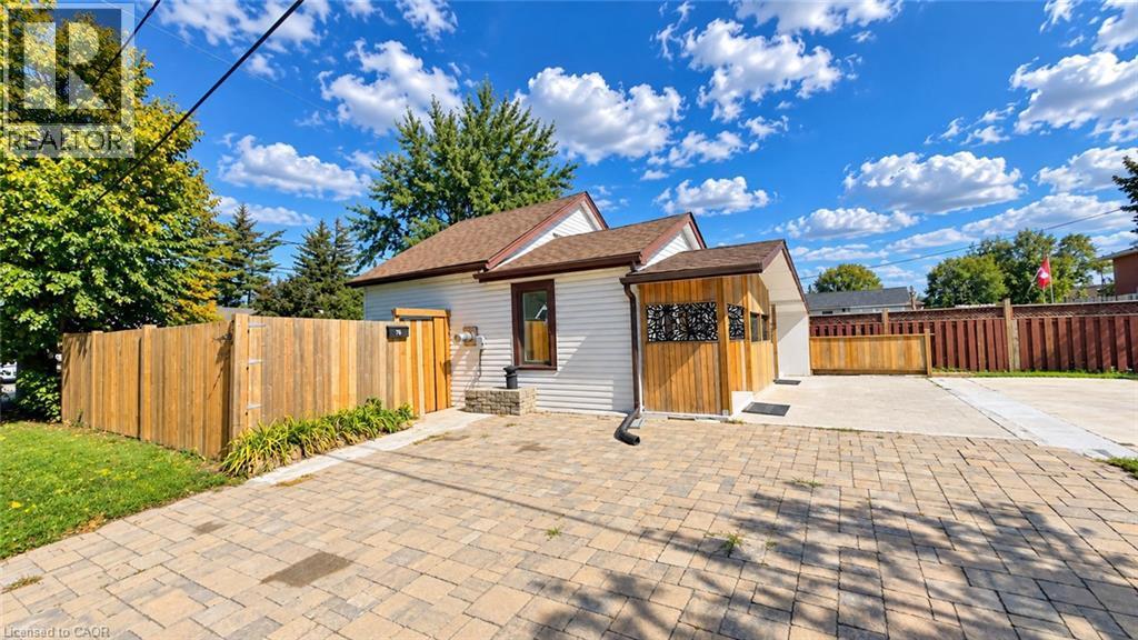 White siding exterior with a brown shingled roof - 76 Avenue Road, Cambridge, ON