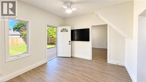 Wood-finish flooring, white walls, ceiling fan, and a door with an arched window - 76 Avenue Road, Cambridge, ON 
