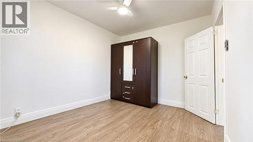 Wood-finish flooring, white paneled door, and a ceiling fan with integrated lighting - 76 Avenue Road, Cambridge, ON 