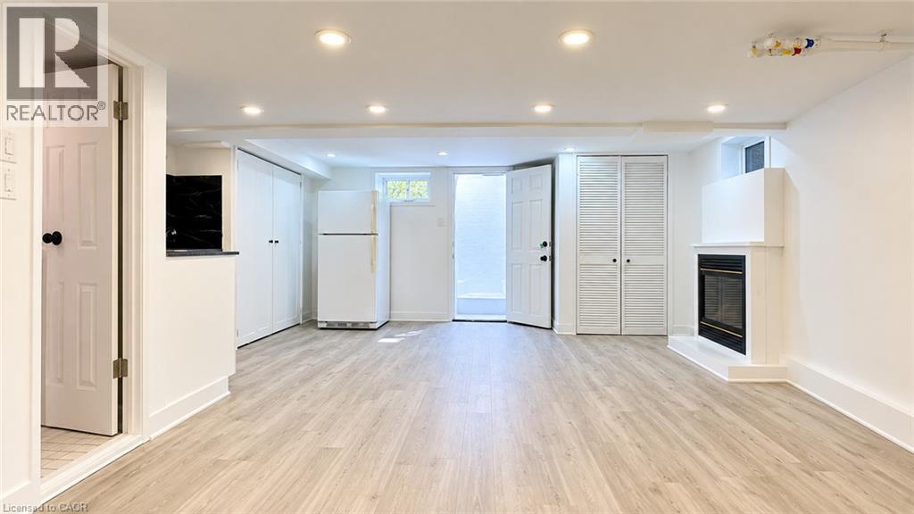 Recessed lighting, wood-finish flooring, built-in fireplace, full-size refrigerator, and built-in cabinetry - 76 Avenue Road, Cambridge, ON