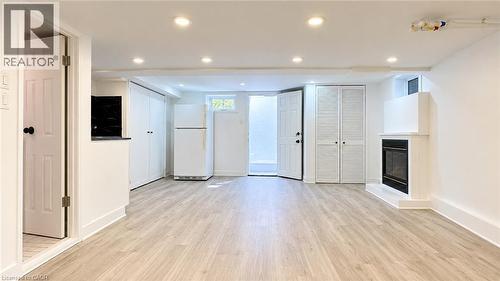 Recessed lighting, wood-finish flooring, built-in fireplace, full-size refrigerator, and built-in cabinetry - 76 Avenue Road, Cambridge, ON 