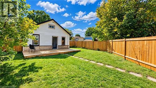 Expansive grass yard with a wood privacy fence, featuring a large outdoor deck and white siding exterior - 76 Avenue Road, Cambridge, ON 