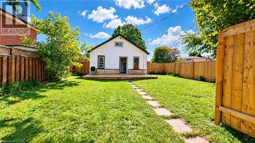 Expansive backyard featuring a manicured lawn, a wooden deck, and a stone-paver pathway - 76 Avenue Road, Cambridge, ON 