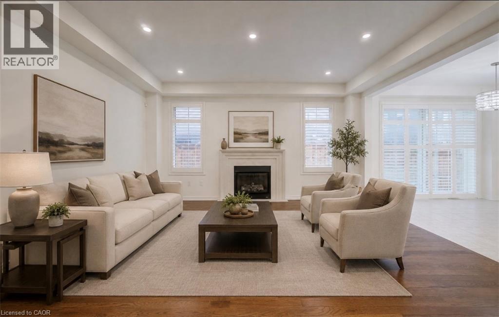 Recessed lighting illuminating the high ceilings, a fireplace with a mantel, dark wood-finish flooring, and white window shutters - 52 Pointer Street, Cambridge, ON