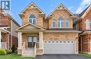Brick exterior with light-colored siding accents, arched windows, covered porch with columns, and a two-car garage - 61 Duckworth Road, Cambridge, ON 