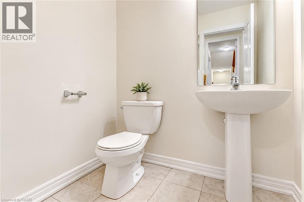 Pedestal sink with chrome faucet, wall-mounted mirror, and tile flooring - 61 Duckworth Road, Cambridge, ON