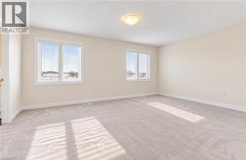 Spacious room with plush carpeting, neutral wall finishes, multiple windows, and a flush mount ceiling light - 61 Duckworth Road, Cambridge, ON 