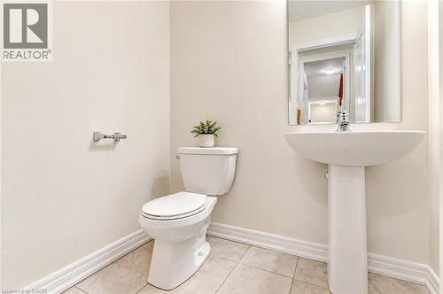 Pedestal sink with chrome faucet, wall-mounted mirror, and tile flooring - 61 Duckworth Road, Cambridge, ON 