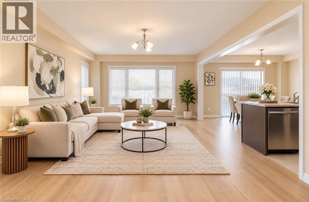 Expansive open-concept living area featuring wood-finish flooring, recessed lighting, large windows with blinds, and a kitchen island with integrated stainless steel dishwasher - 61 Duckworth Road, Cambridge, ON