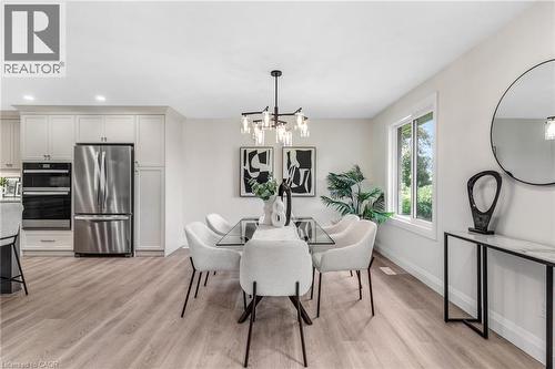 Contemporary open-concept space featuring light wood-finish flooring, recessed lighting, and a modern chandelier - 46 Esther Avenue, Cambridge, ON 