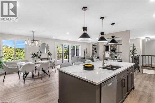 Spacious kitchen island with a double basin sink, stainless steel dishwasher, and pendant lighting - 46 Esther Avenue, Cambridge, ON 